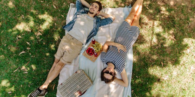 A couple enjoying a picnic on their romantic getaway in Michigan.